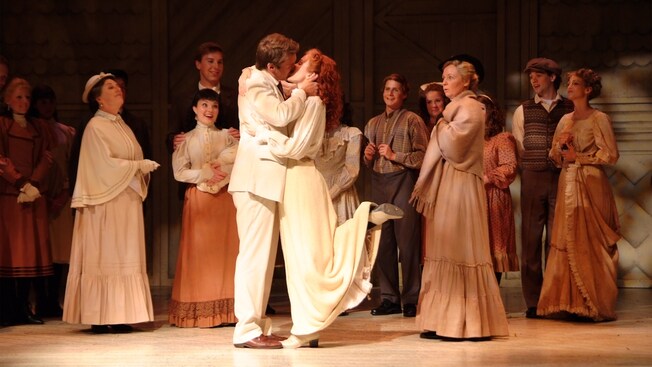 Los dos personajes principales Anne y Gilbert se besan en el escenario mientras el resto del elenco mira