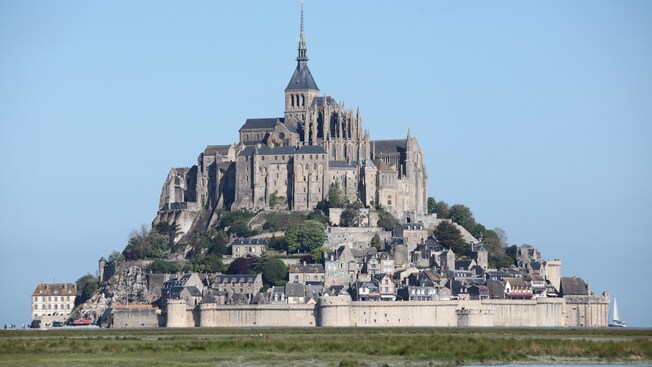 Um castelo com uma catedral e uma vila cercada por fortificações