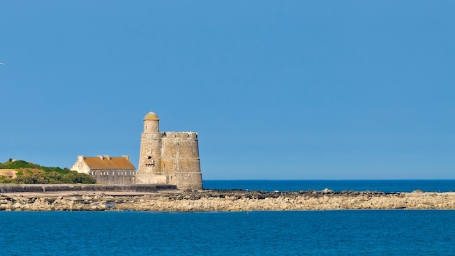 A castle and a building on a coastline