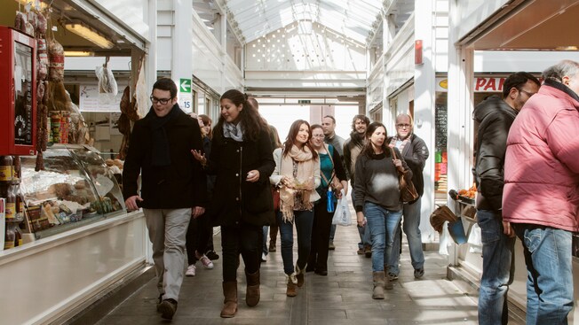 Un grupo de personas camina por las tiendas deli
