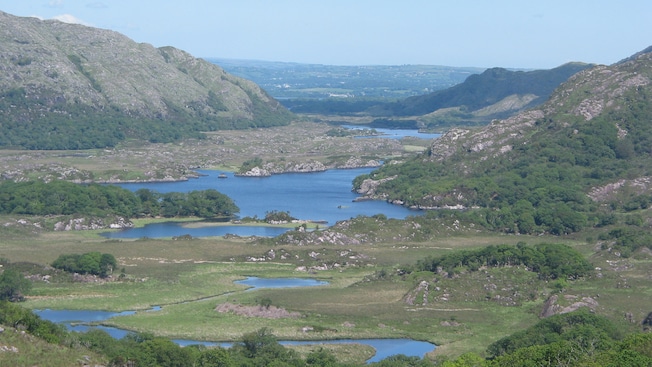 Lowlands covered in trees, grass and bodies of water near hills Lowlands covered in trees, grass and bodies of water near hills