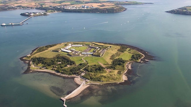 An aerial view of tiny Spike Island surrounded by water with a land mass nearby An aerial view of tiny Spike Island surrounded by water with a land mass nearby