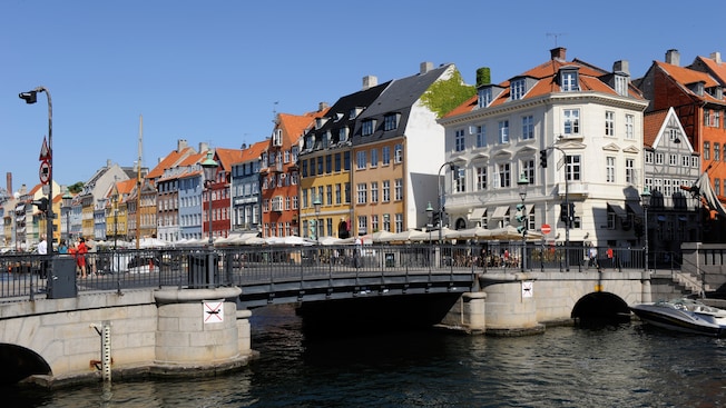 A bridge over a canal lined with cafes and historical gabled buildings A bridge over a canal lined with cafes and historical gabled buildings