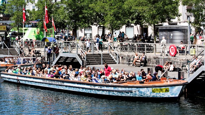 Pasajeros a bordo de una embarcación turística atracada junto al canal