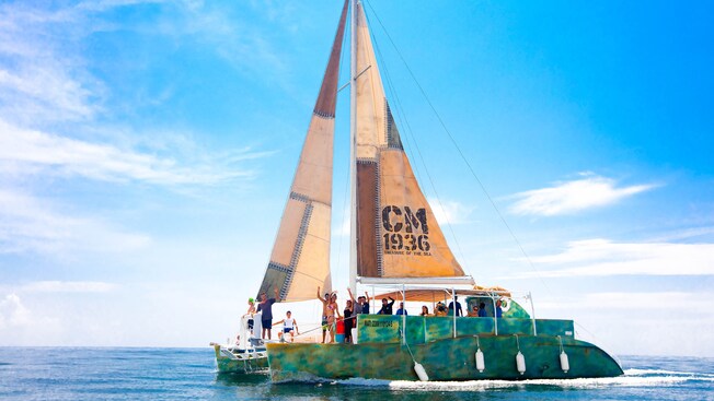Passengers on a catamaran waving and smiling