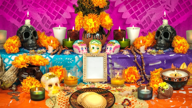 Uma homenagem de altar de cores vivas com caveiras decorativas, velas e bugigangas Uma homenagem de altar de cores vivas com caveiras decorativas, velas e bugigangas