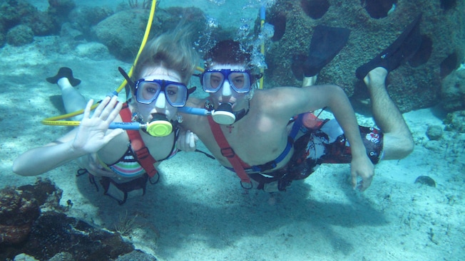 A snuba diving couple poses for a picture underwater