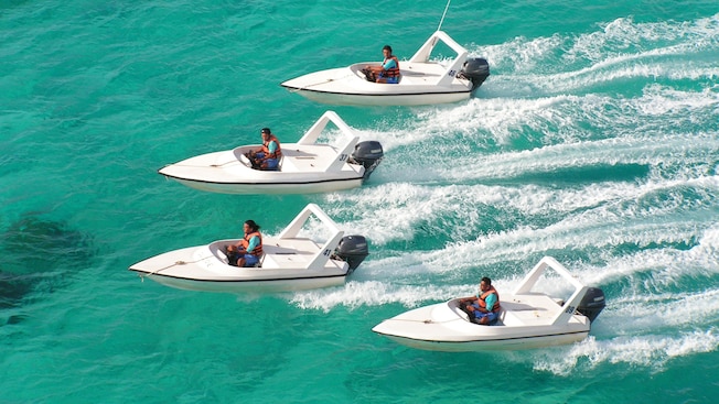 Four, single-seat power boats in a V formation on the ocean Four, single-seat power boats in a V formation on the ocean