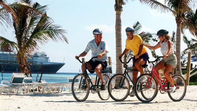 3 Guests ride bicycles along an oceanfront path