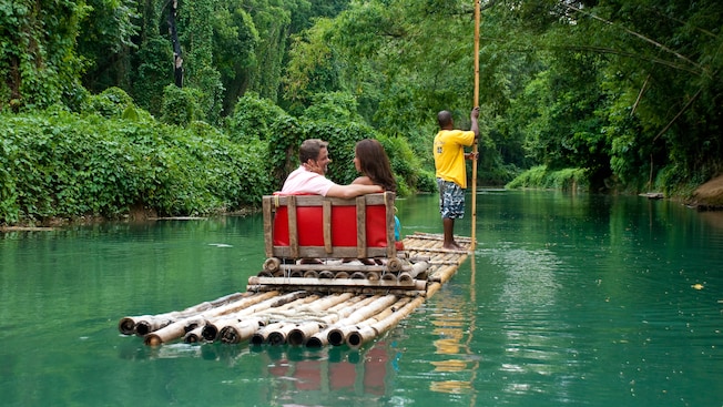 A couple look adoringly into each other's eyes as they enjoy a bamboo raft ride down the river A couple look adoringly into each other's eyes as they enjoy a bamboo raft ride down the river