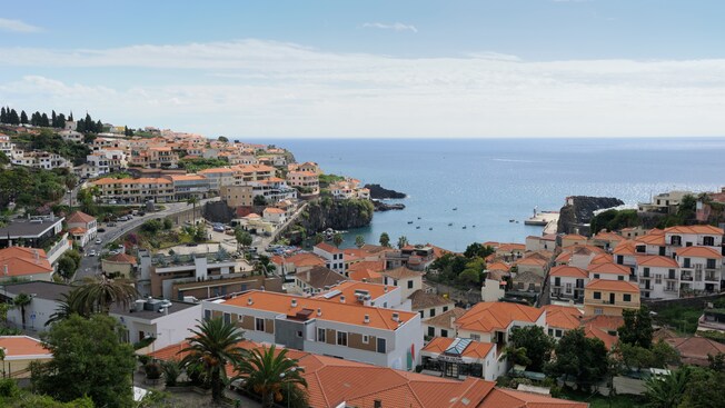 Rooftops on a hillside over a crescent shaped cove