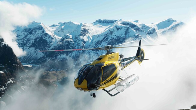 A helicopter flying above snowcapped mountains