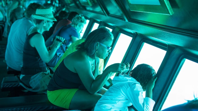 A mother and daughter view sea life through the observation windows of a semi submarine A mother and daughter view sea life through the observation windows of a semi submarine