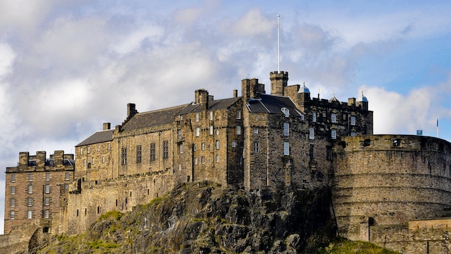 Majestic Edinburgh Castle perched on the edge of a rocky cliff Majestic Edinburgh Castle perched on the edge of a rocky cliff