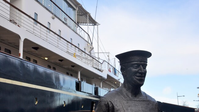 El costado de un barco y la estatua de un marinero en primer plano