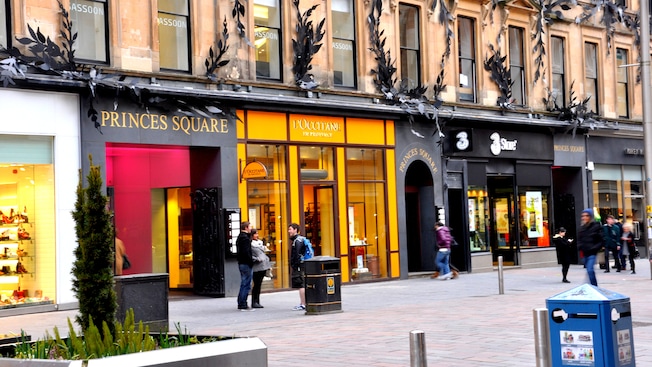 Stores of Princes Square front a brick lined street
