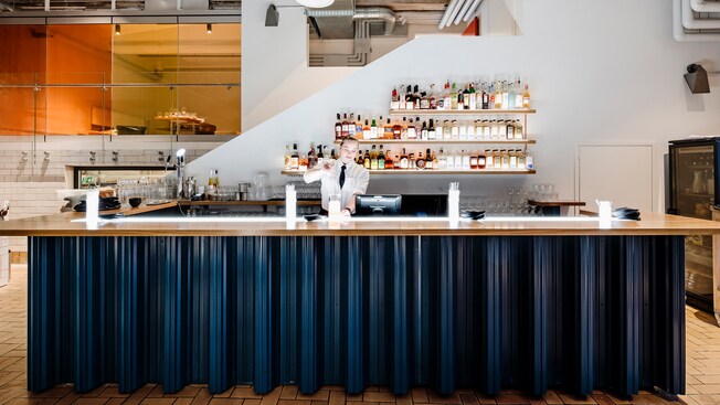 Um barman mistura uma bebida num bar