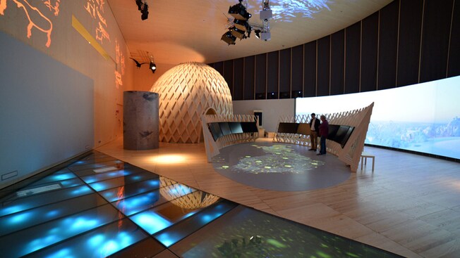 A contemporary exhibition area combining natural wood with digital equipment