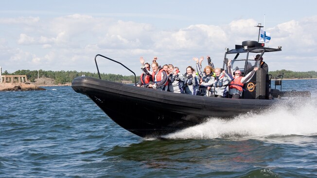 About 15 passengers wave from aboard a speeding Rigid Inflatable Boat