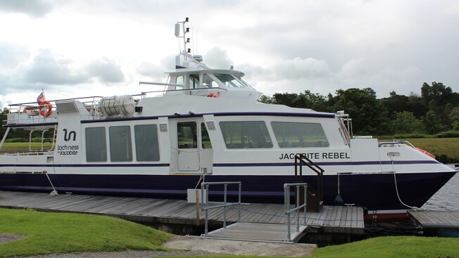 Um barco de passeio chamado Jacobite Rebel ancorado na doca