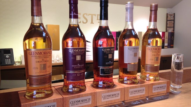 A display of different Glenmorangie Single Malt Scotch Whisky products next to a shot glass A display of different Glenmorangie Single Malt Scotch Whisky products next to a shot glass
