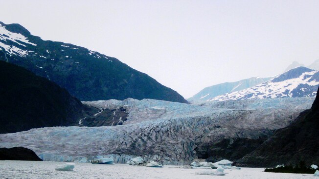 A few small ice floes floating at the base of Mendenhall Glacier