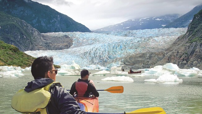 People kayaking by Mendenhall Glacier, icebergs and mountains