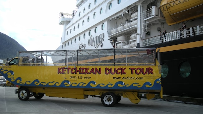 An amphibious truck shaped like a boat has a sign along its side that says Ketchikan Duck Tours An amphibious truck shaped like a boat has a sign along its side that says Ketchikan Duck Tours