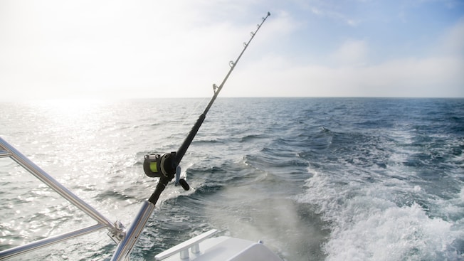 Uma vara de pescar está pendurada na parte de trás de um barco Uma vara de pescar está pendurada na parte de trás de um barco