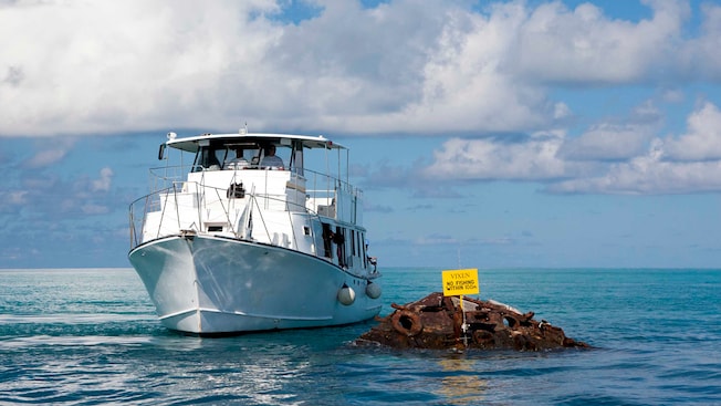 A boat near a shipwreck and a sign that reads Vixen No Fishing Within 100m A boat near a shipwreck and a sign that reads Vixen No Fishing Within 100m