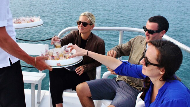 A man hands 2 women and a man drinks