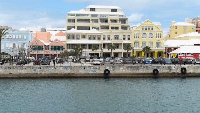 Cars parked along a waterfront lined with buildings
