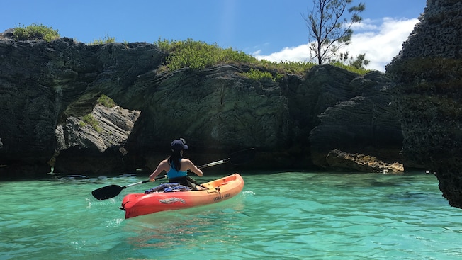 A female Guest explores the aquatic terrain aboard a kayak