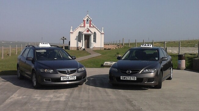 Two taxis parked outside the Italian Chapel in the Orkney Islands
