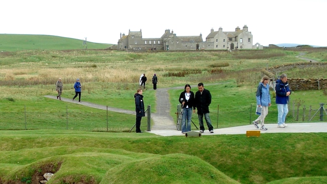 The Skaill House sits in the background as visitors survey the Stone Age settlement of Skara Brae The Skaill House sits in the background as visitors survey the Stone Age settlement of Skara Brae