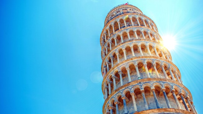 O sol brilha forte atrás da inclinada Torre de Pisa