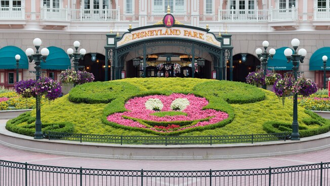 The entrance to Disneyland Paris featuring a floral and greenery display shaped like Mickey Mouse