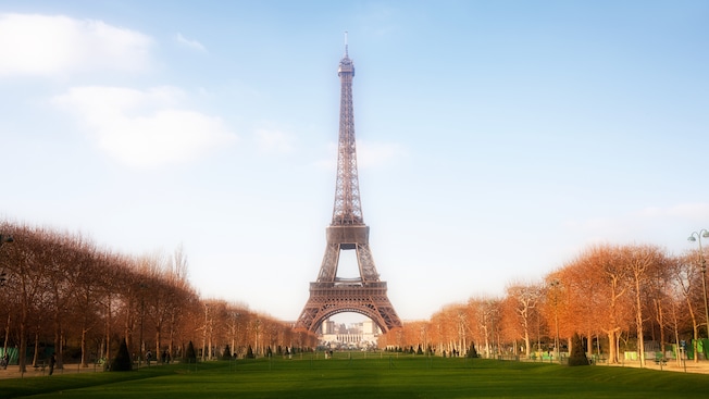 A Torre Eiffel cercada por um longo gramado e árvores A Torre Eiffel cercada por um longo gramado e árvores