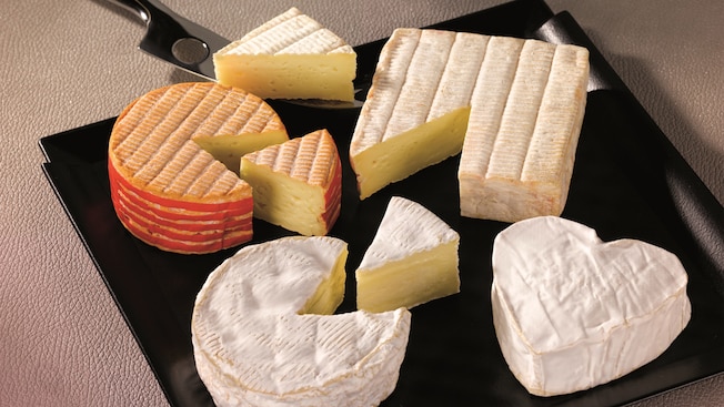 A variety of cheeses placed on a board for sampling A variety of cheeses placed on a board for sampling