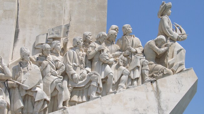A sculpture featuring explorers with objects that define their contributions to each port of discovery