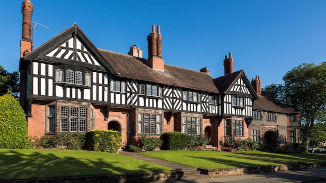 A building featuring archways, windows, chimneys and a front lawn A building featuring archways, windows, chimneys and a front lawn