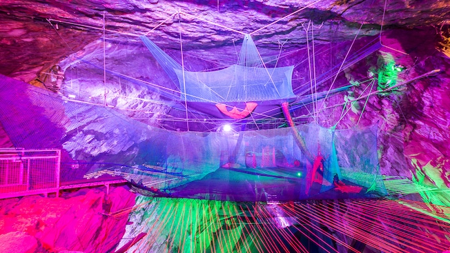 A subterranean playground area featuring trampoline like nets A subterranean playground area featuring trampoline like nets