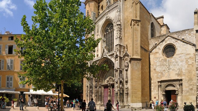 Una catedral histórica en medio de una ciudad llena de gente, edificios y árboles