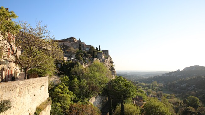 A town built near a cliff, trees and a valley