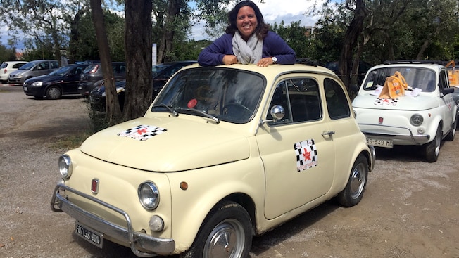 A smiling woman leaning over a FIAT A smiling woman leaning over a FIAT