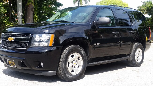 A large Chevy Tahoe SUV with trees in the background