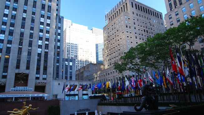 Large concrete buildings surround a plaza lined with the flags of several states Large concrete buildings surround a plaza lined with the flags of several states