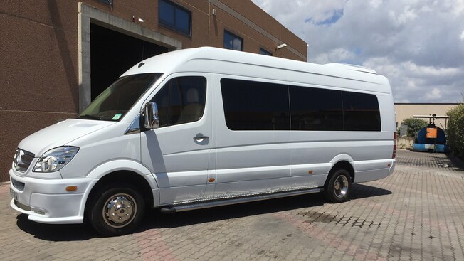 The side of a shiny Mercedes minibus with tinted windows