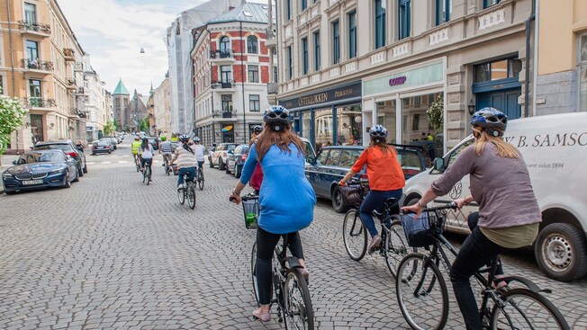 Personas con cascos que andan en bicicleta en la calle