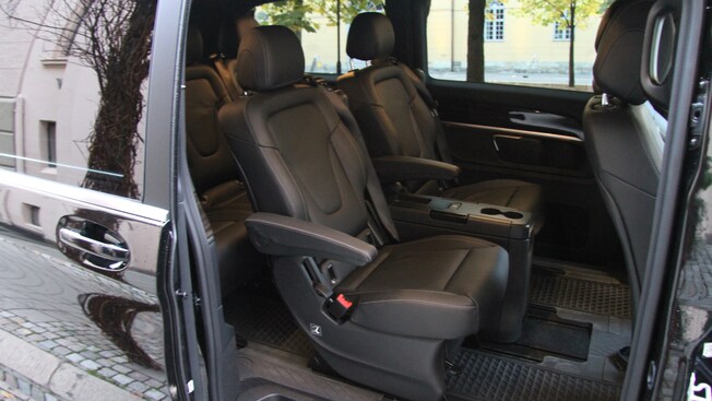 The middle row of a van with two leater seats and a console between them